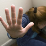 Woman cowering in a corner