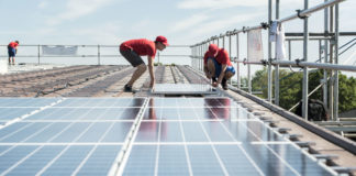 Klimaschutz: Darum geht’s beim Stromgesetz Zwei Männer montieren Solarkollektoren auf einem Dach.