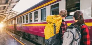 Zugfahren beliebter: Vueling bietet keine Kurzflüge zwischen Madrid-Barcelona mehr an Zwei Backpacker schauen einem Zug beim Einfahren zu