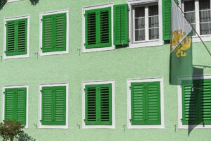 Ein grünes Haus im Thurgau mit dem kantonalen Wappen und grünen Fensterläden.