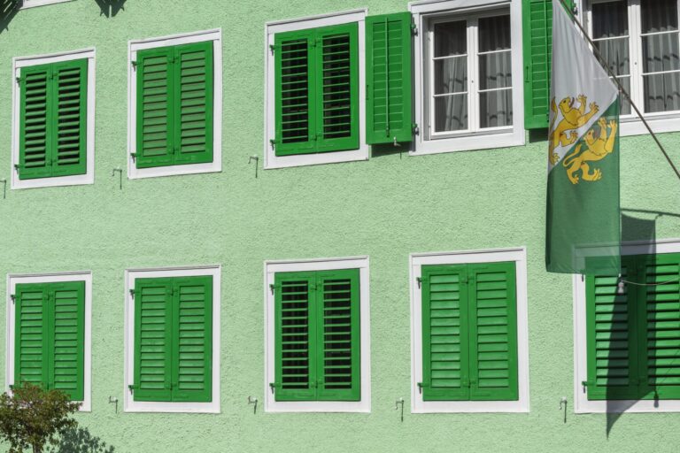 Ein grünes Haus im Thurgau mit dem kantonalen Wappen und grünen Fensterläden.
