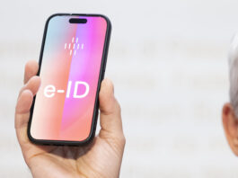 Öffentliche e-ID wird unabhängig von Tech-Konzernen Ein Mann hält ein Smartphone hoch, auf dessen Bildschirm gross ‹e-ID› steht. Die Darstellung symbolisiert die geplante elektronische Identität der Schweiz