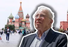 Worum es der SVP bei der Neutralitätsinitiative wirklich geht Porträt eines älteren Mannes mit weissem Haar, Brille und blauem Anzug, freigestellt vor dem Hintergrund des Roten Platzes in Moskau mit der Basilius-Kathedrale und Touristen.